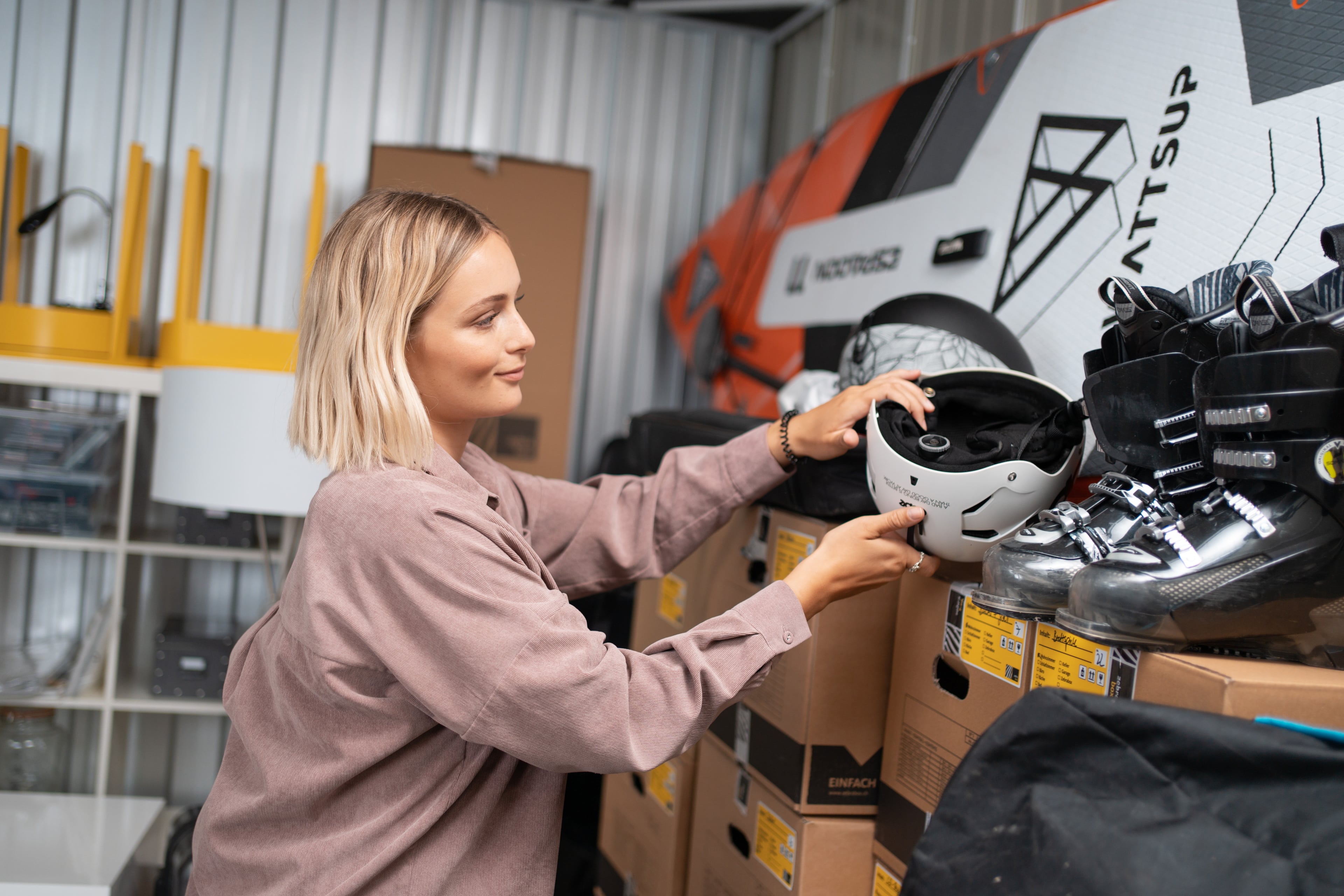 Una joven guarda un casco de esquí en el trastero Zebrabox.